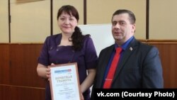 Ульяна Михайлова вручает Игорю Иванову профсоюзную грамоту