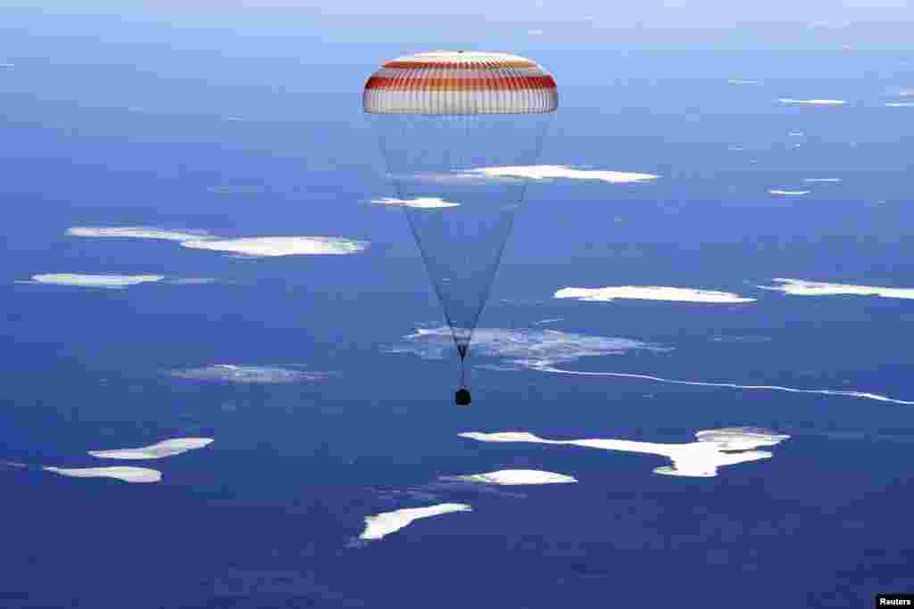 A Russian Soyuz MS-02 space capsule carrying the International Space Station (ISS) crew members descends before landing in a remote area outside the town of Zhezkazgan, Kazakhstan, on April 10. (Reuters/Kirill Kudryavtsev)