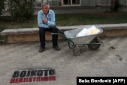 An ethnic Albanian man rests near graffiti reading "Boycott of the census" in the southern Serbian city of Bujanovac in October 2011.