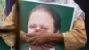A supporter of ousted former Pakistani prime minister Nawaz Sharif held his picture at the venue where his younger brother Shahbaz Srarif led a rally towards the airport in ahead of the arrival in Lahore on July 13.
