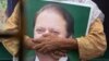 FILE: A supporter of former Pakistani Prime Minister Nawaz Sharif holds his picture at Lahore airport ahead of his arrival in July 2018.