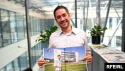 Zachary Peterson poses with the center spread on RFE/RL's headquarters in the recent issue of Era 21 magazine.