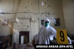 A Pakistani security official inspects the scene of a terrorist attack at Peshawar University in Peshawar in December 2017.