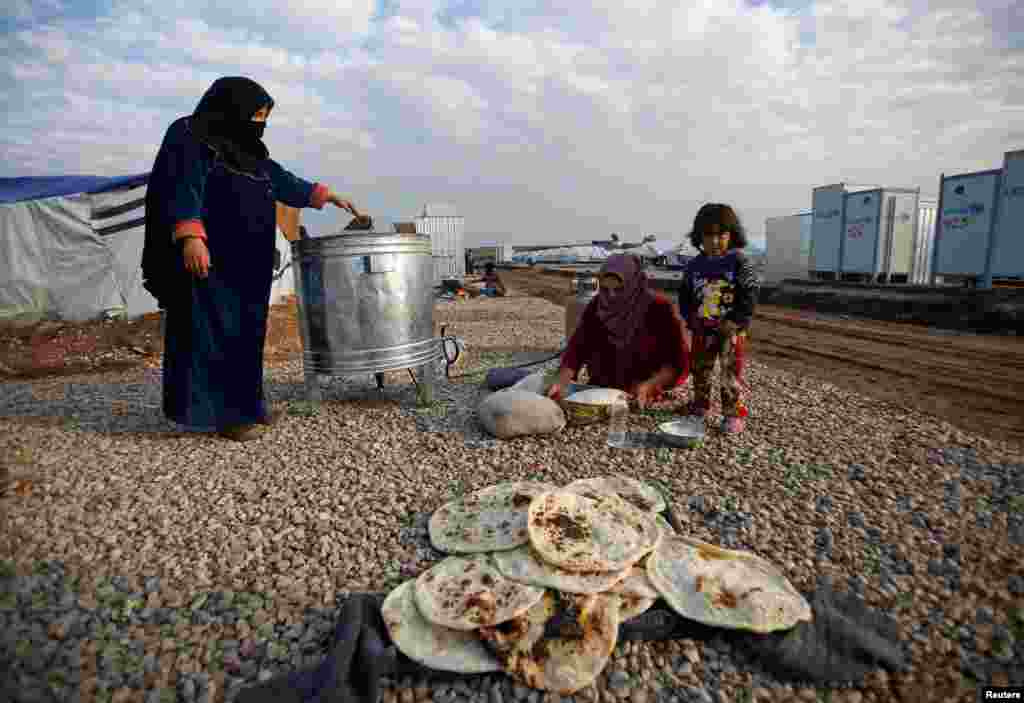 Displaced women, who fled the Islamic State stronghold of Mosul, make bread in a camp, east of the Iraqi city on December 27. (Reuters/Khalid al Mousily)