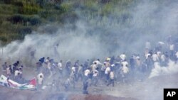 Syria -- Pro Palestinians protesters run from tear gas fired by Israeli troops along the border between Israel and Syria near the village of Majdal Shams in the Golan Heights, 05Jun2011