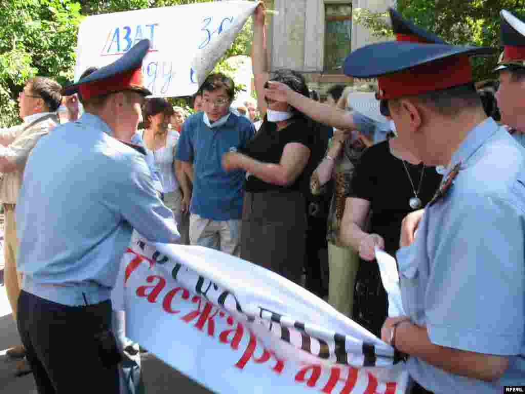 Kazakhstan - a policemen took off a posters from participants of protest action for press freedom. Almaty, 24Jun2009