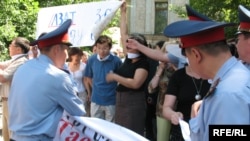 Полицейлер сөз бостандығын қорғау шарасын ұйымдастырушылардың ұрандарын тартып алып жатыр. Алматы, 24 маусым 2009 жыл 