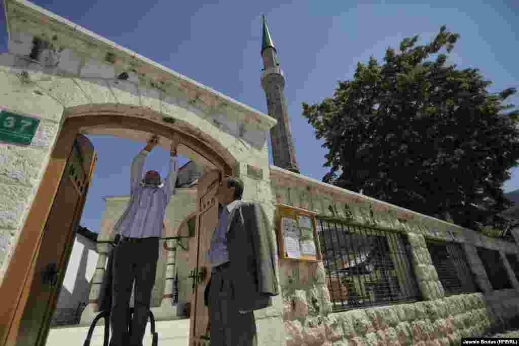 Men repair a door at the entrance to the courtyard of the mosque in the Bascarsija, the old bazaar and historical and cultural center of Sarajevo.