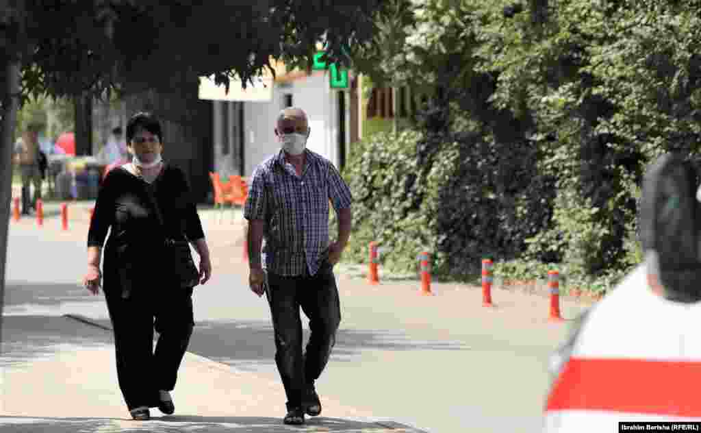 Dy qytetarë me maska duke kaluar në oborrin e Klinikës Infektive në Prishtinë.