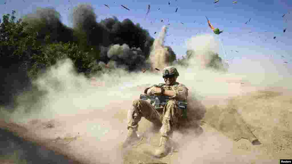 A U.S. Army Private takes cover during a controlled detonation to clear an area for setting up a checkpoint in Afghanistan's Kandahar Province. 