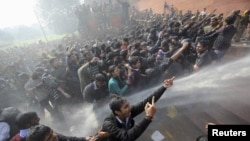 Demonstrators shout slogans as police use water cannons to disperse them near the presidential palace during a protest rally held in New Delhi late last month after a young woman was gang raped by several men on a bus.