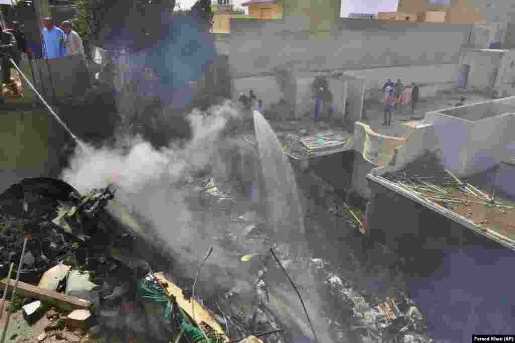 Egy repülőgépkatasztrófa miatt bekövetkezett tüzet próbálnak eloltani. A tragédia Karacsiban, Pakisztánban történt május 22-én.