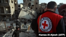 An International Red Cross volunteer stands near the rubble of a destroyed building in Douma in the Syrian rebel enclave of eastern Ghouta on the outskirts of Damascus on March 5.