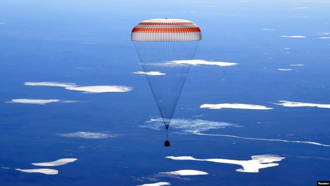 The Russian Soyuz MS-02 space capsule carrying the International Space Station (ISS) crew descends toward a remote area in Kazakhstan.