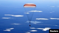 The Russian Soyuz MS-02 space capsule carrying the International Space Station (ISS) crew descends toward a remote area in Kazakhstan.