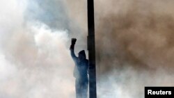 A supporter of the Muslim Brotherhood and ousted Egyptian President Mohamed Morsi gesticulates amid tear gas released by riot police during clashes outside Cairo University late last month.