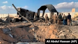 U.S. soldiers and journalists stand near a crater caused by an Iranian missile strike at the Ain al-Asad air base in January, following the U.S. strike that killed Iranian General Qasem Soleimani. 