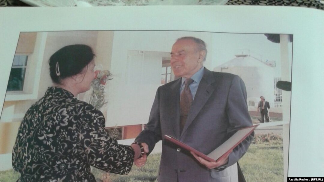 Heydər Əliyev bina sakinlərinə order və açarları təqdim edir. 