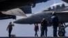 US sailors prepare to taxi a fighter jet on the flight deck of the USS Abraham Lincoln aircraft carrier in the Middle East. 