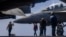 US sailors prepare to taxi a fighter jet on the flight deck of the USS Abraham Lincoln aircraft carrier in the Middle East. 