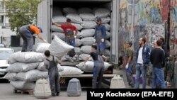 Жүк түшүрүп аткан мигранттар. Москва, 12-сентябрь, 2018-жыл.