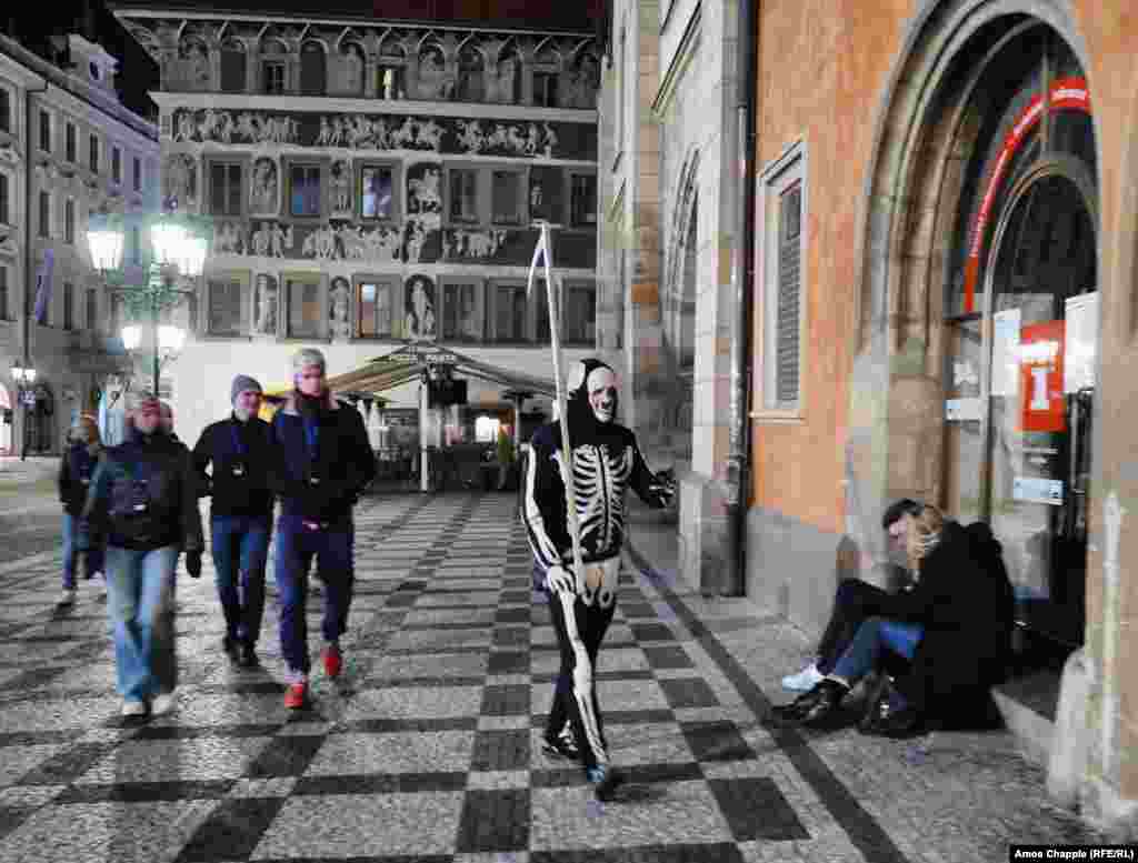 A Ukrainian man in a grim reaper costume running a Russian-language &quot;legends of Prague&quot; tour in the Old Town. The man told RFE/RL that the amount of foot traffic was down by about 75 percent compared to before the virus outbreak.&nbsp;