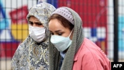 Women wearing face masks to protect themselves from air pollution walk on a street in Tehran on November 29.