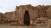 Children play soccer in front of the empty seat of one of two Buddha statues in Bamiyan province, which was destroyed by the Taliban in 2001.