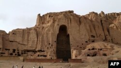 Afghan boys play soccer in front of the empty seat of one of two Buddha statues destroyed by the Taliban in 2001 in Bamiyan Province.