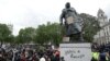 Statuia fostului prim-ministru britanic Winston Churchill cu inscripția [Churchill] „a fost rasist” scrisă pe soclu, în Piața Parlamentului din centrul Londrei, după o demonstrație în fața ambasadei Statelor Unite, 7 iunie 2020.