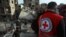 An International Red Cross volunteer stands near the rubble of a destroyed building in Douma in the Syrian rebel enclave of eastern Ghouta on the outskirts of Damascus on March 5.