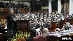 Afghan President Hamid Karzai (standing) addresses the Afghan parliament in February 2010.