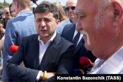 Ukrainian President Volodymyr Zelenskiy (left) talks to local residents in the central city of Cherkasy on July 31.