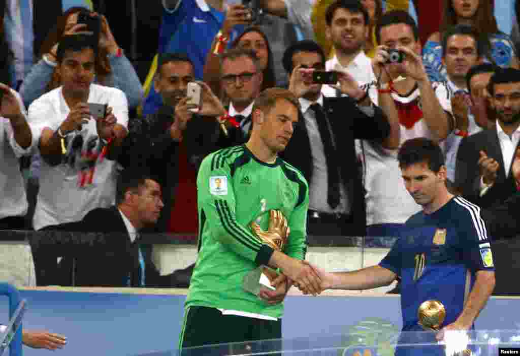 Brazil -- Germany's goalkeeper Manuel Neuer and Argentina's Lionel Messi shake hands after receiving the Golden Glove and Golden Ball awards respectively, after their 2014 World Cup final at the Maracana stadium in Rio de Janeiro, July 13, 2014