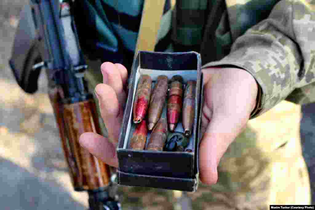 A Ukrainian sergeant shows rounds from a high-powered sniper rifle that were pulled out of the buildings and sandbags around his squad&#39;s position. April 9, 2016