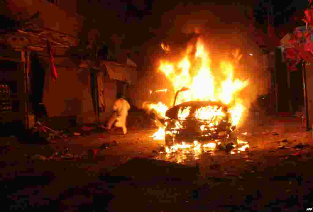 A Pakistani man runs past a burning vehicle after a suicide bomb attack on an election campaign rally in Peshawar. (AFP)