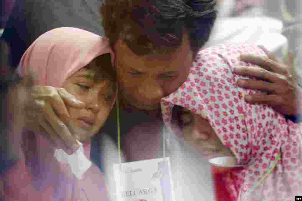 Relatives react at the news that debris had been found from the missing AirAsia plane at Juanda Airport in Surabaya, Indonesia. (epa/Made Nagi)