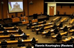 Президент України Володимир Зеленський (на екрані) під час звернення через відеозв'язок до парламенту Кіпру. Нікосія, 7 квітня 2022 року