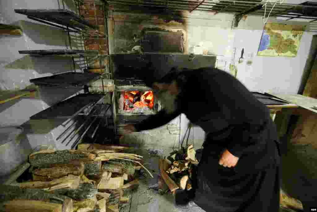 A man heats an oven at the Martkopi Orthodox monastery, some 30 kilometers from Tbilisi, Georgia. (epa/Zurab Kurtsikidze)