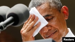 U.S. President Barack Obama wipes the sweat from his brow as he speaks about climate change at Georgetown University in Washington on July 25.