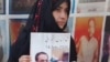 Haseeba Qambrani holds the photo of her disappeared brother Hassan Qambrani at a sit-in protest in Quetta, Balochistan.