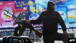 Ішкі істер министрлігі маңында көшені бақылап тұрған полиция киіміндегі қарулы адам. Кабул, 2 сәуір 2014 жыл. (Көрнекі сурет)