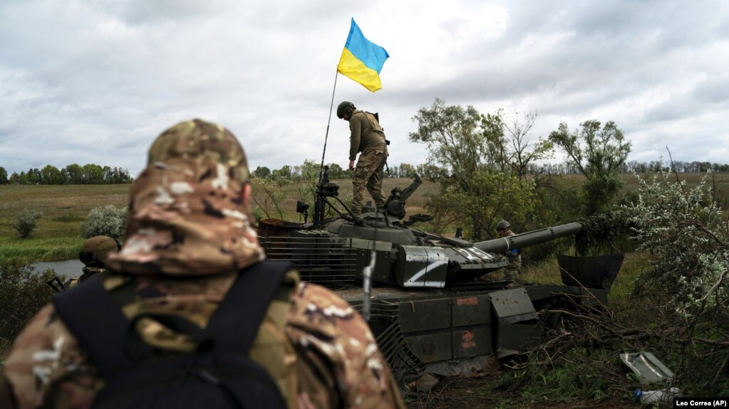 Боєць Нацгвардії України стоїть на підбитому російському танку біля кордону з Росією, Харківська область, 19 вересня 2022 року