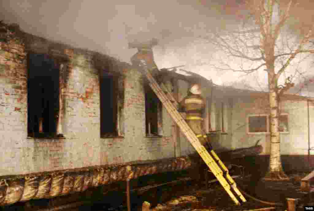 Firefighters work among the remains of the Novokhopersky psychiatric home, which was destroyed by a fire, in the village of Alferovka in Russia's Voronezh region. At least 23 people were killed in the blaze. (TASS)