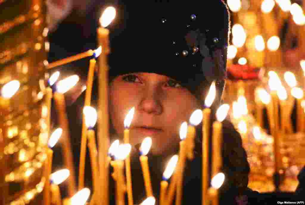 Дівчина запалює свічку на Різдво в Казанському соборі в Санкт-Петербурзі, Росія