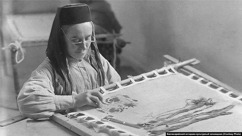 An embroiderer works in Bakhchysaray. Crimean Tatar clothes, shoes, and textiles could not be imagined without embroidery. Ornaments differed by region. Fish and boat patterns were used in the embroideries of eastern Crimea, while embroiderers on the steppe preferred a burgundy color. Algae were depicted on the southern coast with lilac, violet and white colors predominating.