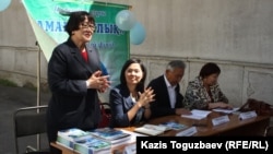 Неправительственная организация "Аман-саулык" презентует книгу "Ваше право на здоровье". Слева - руководитель НПО Бахыт Туменова. Алматы, 13 мая 2014 года. 