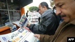 Iraq -- Kurdish men read newspapers headlines at a news stand in the northern city of Irbil, 08Mar2010