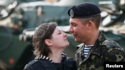 A Ukrainian marine speaks with his wife after a welcoming ceremony in Kyiv after their return from a military base in the Crimean port city of Feodosia.