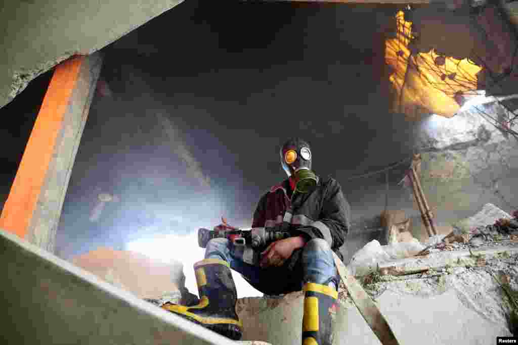 A civil-defense member sits near a site hit by an air strike in the rebel-held Douma neighborhood of Damascus, Syria. (Reuters/Bassam Khabieh)